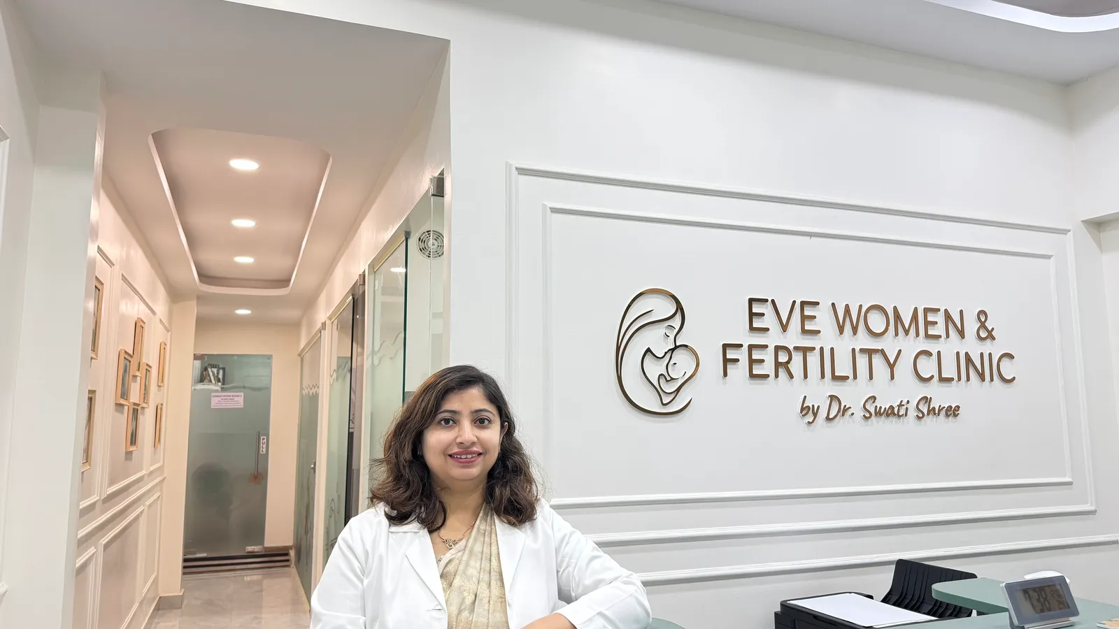 The EVE reception area with the clinic wall sign and Dr. Swati Shree standing beside it.
