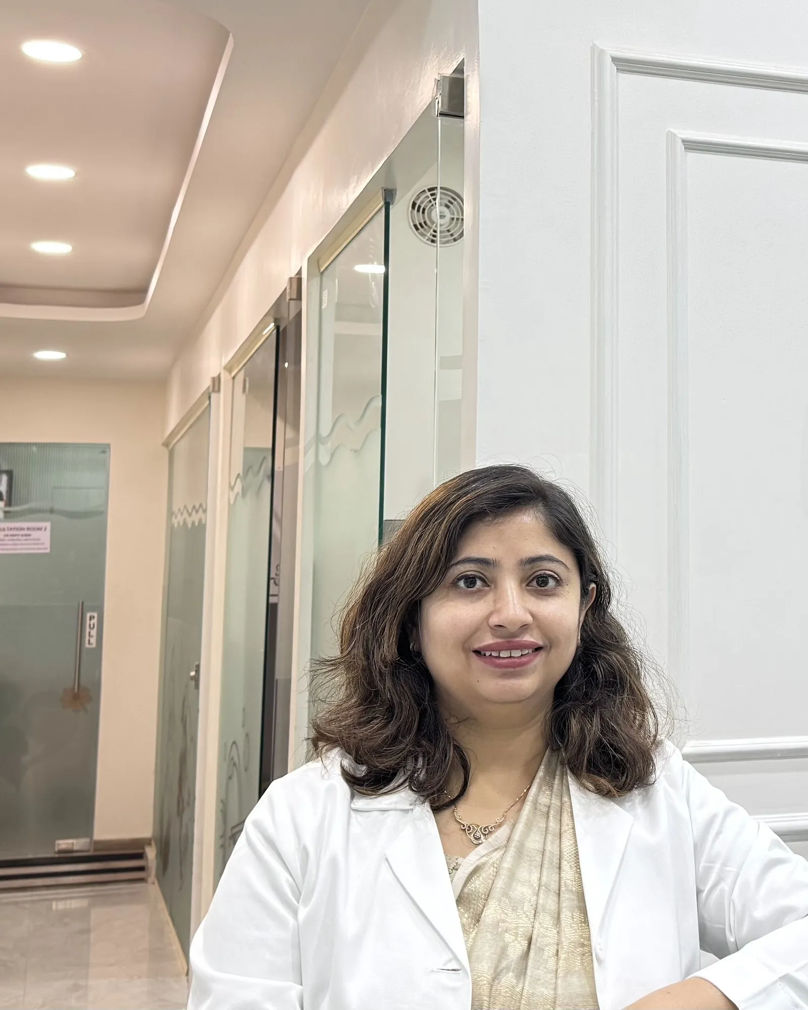 Dr. Swati Shree in a white coat standing in the clinic corridor.